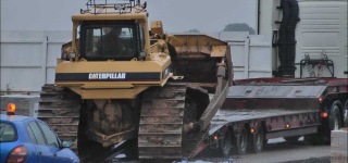 Caterpillar Bulldozer Slides Down Off A Truck