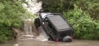 Off-Road 4x4 Jeep Drives up Through the Fierce Waterfall